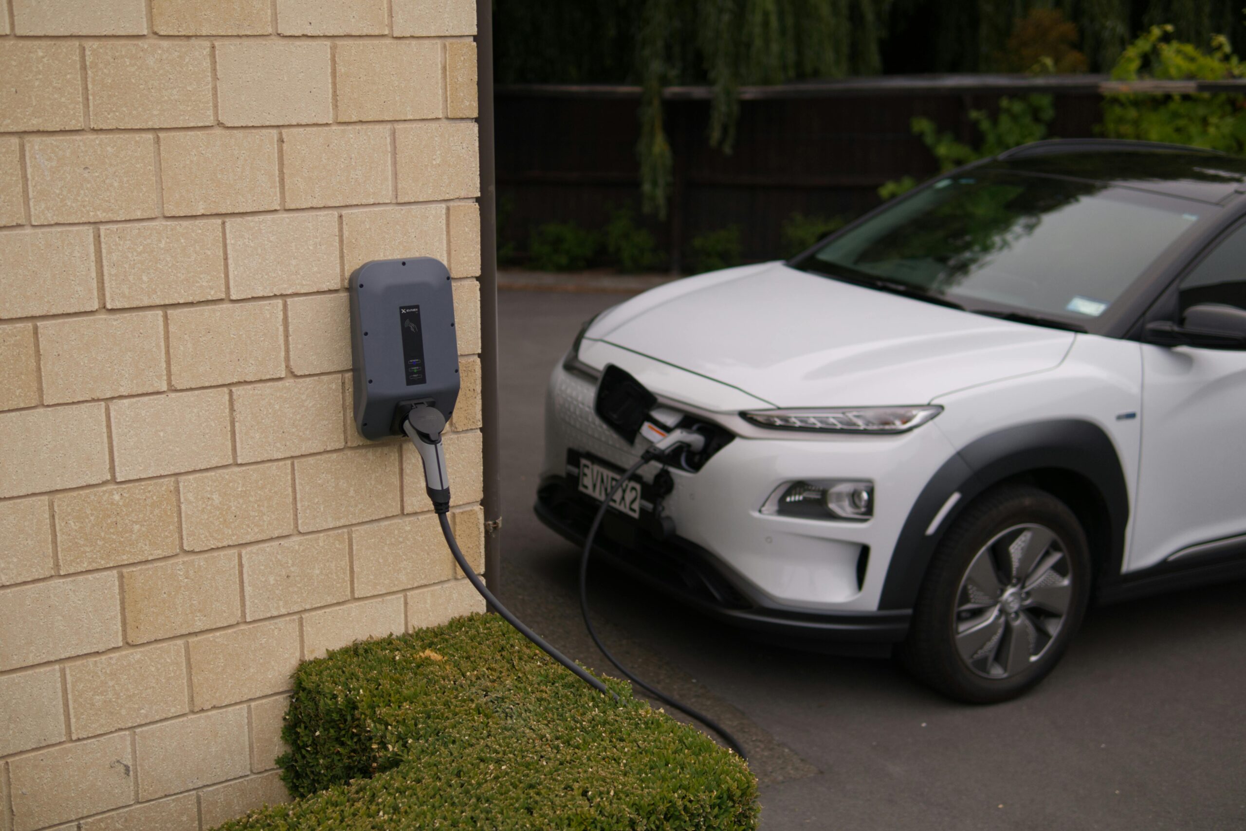 image of a white car plugged into an ev charger